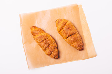 Two croissants on brown baking paper