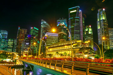 Singapore skyline of Business District and pedestrian bridge in marina bay promenade. Singapore night lights of the marina bay.