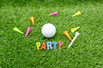 Golf Party invitation with golf ball and colourful tees on green grass
