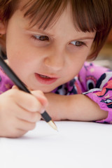 Little beautiful child girl learns to write outdoors. Preschool, development, education concept.