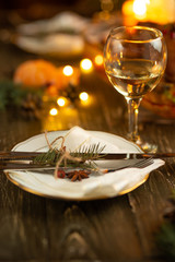 Festive table setting bowls and cutlery, glasses of wine against a background of baked duck