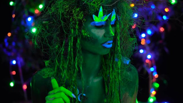 Wild Mystic green dryad in UV fluor black light with Glowing trees on background