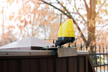 closeup of warning light placed on metal sliding gate