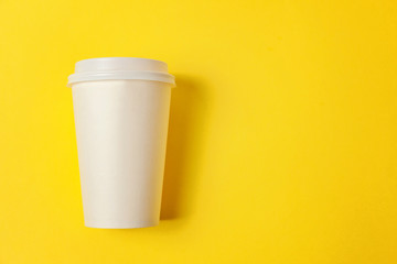 Simply flat lay design paper coffee cup on yellow colorful trendy background. Takeaway drink container. Good morning wake up awake concept. Template of drink mockup. Top view copy space