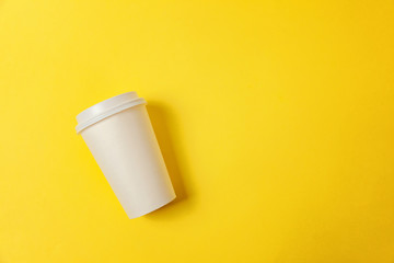 Simply flat lay design paper coffee cup on yellow colorful trendy background. Takeaway drink container. Good morning wake up awake concept. Template of drink mockup. Top view copy space
