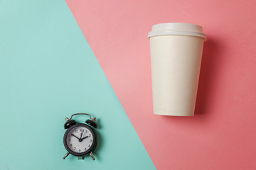 Simply flat lay design paper coffee cup and alarm clock on blue pink pastel colorful trendy...