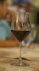 A glass of red wine is placed on the table.