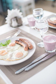Traditional breakfast with  sausages, fried eggs, bread and yogurt
