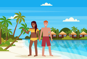 mix race couple on tropical island with villa bungalow hotel on beach seaside green palms landscape summer vacation concept flat horizontal