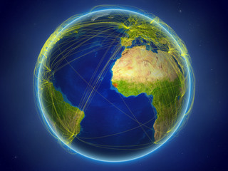 Guinea-Bissau from space on planet Earth with digital network representing international communication, technology and travel.