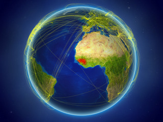 Guinea from space on planet Earth with digital network representing international communication, technology and travel.