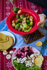 Woman hands holds baked, roasted, grilled vegetables mix assortment with Mexican tacos - corn flat breads. Vegan happy Christmas food lunch on red tablecloth. Vegetarian traditional holiday dinner