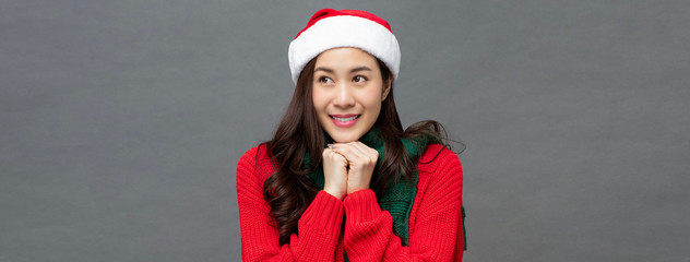 Beautiful asian woman in christmas themed clothes doing an anticipating gesture