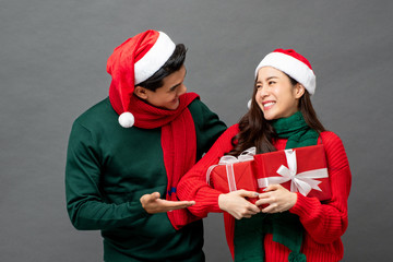 Asian couple wearing colorful red and green sweaters with Christmas gift boxes