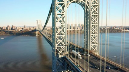Aerial drone footage of George Washington Bridge with view along Hudson River, towards New York City (upward movement)
