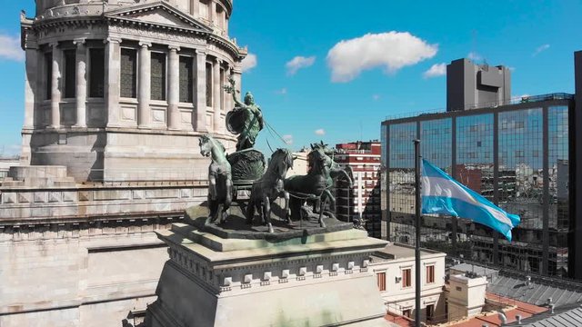 Aerial drone view of Buenos Aires national congress parliament building with dome roof, roman horse carriage statute and argentine flag