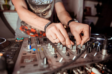 DJ mixer on the table background the night club and dancing people