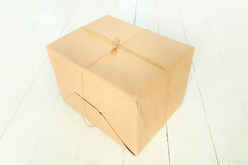 String or twine tied in a box on kraft paper. gift concept. top view.