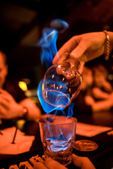 Glass with burning alcohol. Image of two glasses of burning emerald absinthe. Glass of tequila and flames