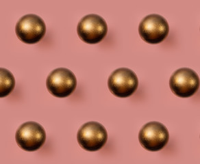 Golden Christmas ball pattern on pink background