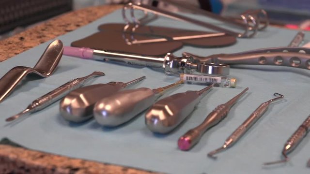 A slow pan across a dental table to show some of the tools used in dental procedures and surgery.