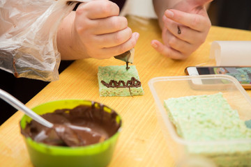 horizontal image with detail of the preparation of some desserts decorated with chocolate cream