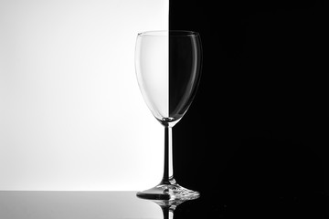Empty glass of wine on white and black background close-up.