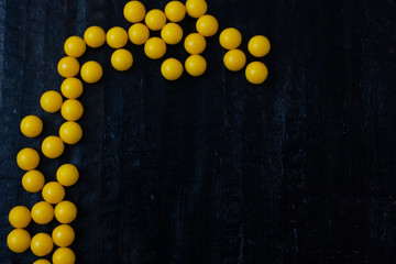 handful of yellow vitamin on a black background