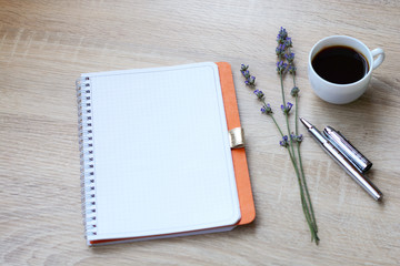 Notepad, pen, flowers (lavender)  on a wooden desk. Writer;