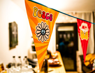 hippie peace text and love flower power van on a hanging party sign over a blurred background
