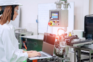 Female industrial engineer wearing hard hat work at factory.