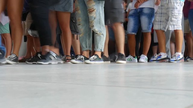 Timelapse of people's feet waiting in line