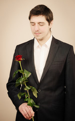 Elegant young man with red rose.