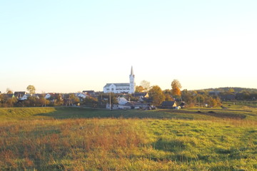 Fototapeta premium village church at sunset warm autumn sun