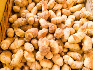 Freshly baked fine rolls sprinkled with sugar on the shelf in the bakery.