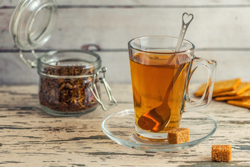 Cup of Herbal tea with cane sugar on grey wooden background