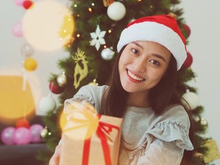 girl in santa hat with christmas gift