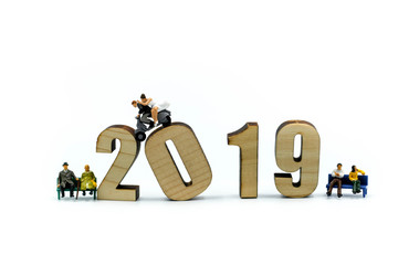 Miniature people : Couple of love with wooden number of 2019,Happy New Year 2019 concept.