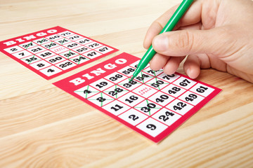 Hand marking bingo winning numbers.