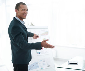 Fototapeta na wymiar successful businessman pointing to a flip chart with the financial information.