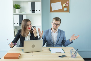 Business, teamwork and people concept - woman and man are working together in office. Bad emotions