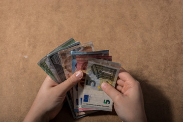 Hand holding American dollar  isolated on wooden background