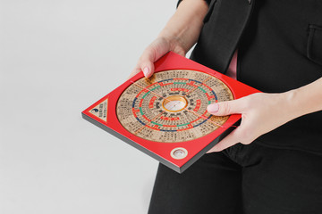 Chinese compass Lopan for Feng Shui technique in female hands isolated