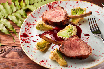 Roasted lamb ribs with berry sauce and broccoli