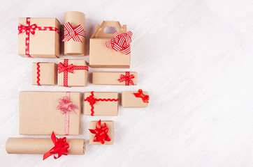 Christmas background - set of various craft paper gifts with red ribbons and bows on soft light...