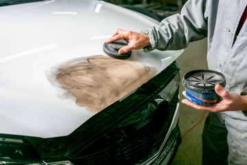 Car repair in car service. Paint work. Locksmith primes car detail, hands close-up