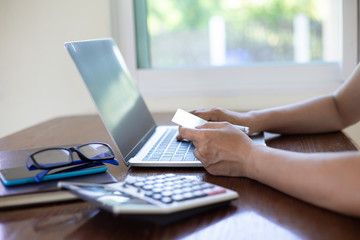 Hand women shoping online by notebook on desk about at coffee shop. shoping online concept
