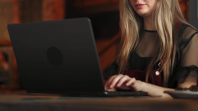 Cropped shot view of young smart female student learning on-line via laptop computer before her lectures, intelligent woman sitting in front open net-book with copy space screen for your text message