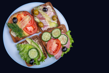 Healthy eating concept.  Several  toasts with salmon and fresh vegetables for a morning breakfast