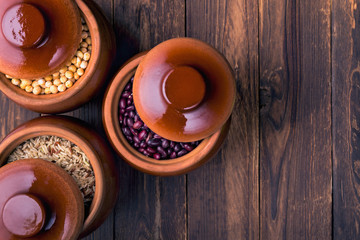 The concept of natural healthy food. Grains of various beans in a large ceramic pots, closeup. Superfood